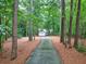 Driveway through trees to a two-car garage home at 1720 Mineral Springs Rd, Hoschton, GA 30548