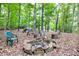 Stone fire pit with chairs in a wooded setting at 1720 Mineral Springs Rd, Hoschton, GA 30548