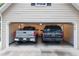 Two-car garage with SUV and pickup truck parked inside at 1720 Mineral Springs Rd, Hoschton, GA 30548