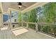 Open-air back porch featuring wood floors, a ceiling fan, and natural outdoor views at 102 Cottage Gate Ln, Roswell, GA 30076