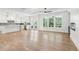 Open-concept living space connecting to the kitchen, featuring hardwood floors and a wall of windows at 102 Cottage Gate Ln, Roswell, GA 30076