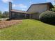 Grassy backyard featuring a small covered patio with a privacy fence in the background at 1084 Village Main St, Stone Mountain, GA 30088