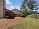 A spacious, grassy backyard featuring a small covered patio and privacy fence at 1084 Village Main St, Stone Mountain, GA 30088