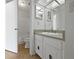 Bathroom features a vanity with sink, mirrored medicine cabinets, and a bathtub with shower, providing functionality at 1084 Village Main St, Stone Mountain, GA 30088