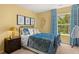 Bedroom with sunny yellow walls and large window with tree view and blue curtains at 338 Elgin Dr, Lawrenceville, GA 30045