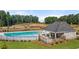 Aerial view of a community pool with a clubhouse and seating area, surrounded by well-manicured landscaping at 338 Elgin Dr, Lawrenceville, GA 30045
