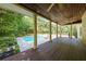 Covered deck overlooking an in-ground pool and landscaped backyard with mature trees at 1357 Baniff Ct, Snellville, GA 30078