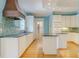 An eat-in kitchen with white cabinets, and hardwood floors at 1357 Baniff Ct, Snellville, GA 30078