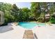 In-ground pool with surrounding patio, mature trees and landscaping, offering a serene backyard retreat at 1357 Baniff Ct, Snellville, GA 30078