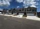 New townhomes feature gray siding, stone accents, and attached garages on a sunny street at 328 Elgin Dr, Lawrenceville, GA 30045