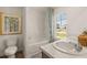 Bright bathroom with a double sink vanity, tub with shower, and large window with community view at 308 Elgin Dr, Lawrenceville, GA 30045