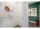 Walk-in closet with wood floor, wire shelves for ample storage, and a view into a bathroom with dark green accent wall at 308 Elgin Dr, Lawrenceville, GA 30045