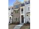 Exterior view showcasing a brick townhome with white accents, a covered entrance, and manicured landscaping at 1956 Deco Dr, Kennesaw, GA 30144