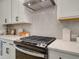 Kitchen detail of gas cooktop and herringbone backsplash at 1996 Deco Dr, Kennesaw, GA 30144