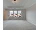 Spacious bedroom featuring neutral carpet, a tray ceiling, and large windows for ample natural light at 1980 Deco Dr, Kennesaw, GA 30144