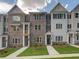 Townhome complex with brick and painted facades, well-maintained lawns, and symmetrical window placement at 1980 Deco Dr, Kennesaw, GA 30144