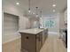View of the kitchen featuring white cabinets, stainless steel appliances, a large island with pendant lighting, and light wood floors at 1980 Deco Dr, Kennesaw, GA 30144