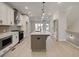 Bright kitchen features white cabinets, stainless steel appliances, large island with pendant lighting, and a herringbone backsplash at 1980 Deco Dr, Kennesaw, GA 30144