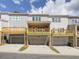 Modern townhome exterior with individual garages and wooden balconies on a partly cloudy day at 1988 Deco Dr, Kennesaw, GA 30144