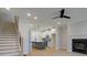 Open-concept living area with hardwood floors, fireplace, stairs, and a view of the modern kitchen and island at 1988 Deco Dr, Kennesaw, GA 30144