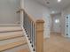 Stylish staircase with light wood treads, a dark metal railing, and a view into the home's entryway at 1988 Deco Dr, Kennesaw, GA 30144