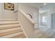 Inviting staircase with wood treads, white risers, and railing with a view of the home's entry at 1988 Deco Dr, Kennesaw, GA 30144