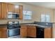 Bright kitchen featuring wooden cabinets, stainless steel microwave, gas range, and a black dishwasher at 1623 Bradmere Ln, Lithia Springs, GA 30122