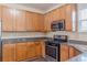 Well-lit kitchen featuring wooden cabinets, stainless steel microwave, and a gas range stove at 1623 Bradmere Ln, Lithia Springs, GA 30122