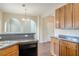 Kitchen view with stainless steel sink, breakfast bar, wooden cabinets and open archway to living area at 1623 Bradmere Ln, Lithia Springs, GA 30122