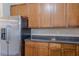 Kitchen view with stainless steel refrigerator, wood cabinets and dark countertops at 1623 Bradmere Ln, Lithia Springs, GA 30122