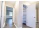 Hallway with an open shelf closet, leading to a room with a window and wainscoting at 1417 Iris Lake Rd, Mcdonough, GA 30252