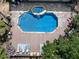 An aerial view of a backyard with a blue pool surrounded by a patio, deck, landscaping, and mature trees at 1012 Jubilee Way, Powder Springs, GA 30127