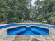 Backyard pool with a small stone waterfall feature surrounded by nature and an iron fence at 1012 Jubilee Way, Powder Springs, GA 30127