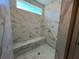 Luxurious walk-in shower featuring designer tile and a built-in bench at 3577 Fishpond Cir, Dacula, GA 30019