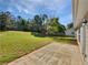 Large backyard featuring mature trees, a wooden fence, and a concrete patio at 424 Eglington Trl, Locust Grove, GA 30248
