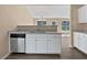 Galley kitchen features white cabinets and updated appliances and granite countertops at 424 Eglington Trl, Locust Grove, GA 30248