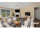 Bright living room with fireplace, ceiling fan, and lots of natural light from large windows at 424 Eglington Trl, Locust Grove, GA 30248