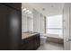 Modern bathroom featuring a granite countertop, large mirror, and a sleek bathtub with tiled backsplash and natural light at 3325 Piedmont Ne Rd # 1801, Atlanta, GA 30305
