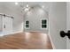 Spacious bedroom with vaulted ceiling, wood-look flooring, and barn door at 136 Rainey Rd, Temple, GA 30179