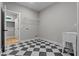 Bright laundry room features stylish black and white checkered floor and built-in shelving at 136 Rainey Rd, Temple, GA 30179