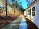 Side yard with pine straw and a concrete walkway at 136 Rainey Rd, Temple, GA 30179