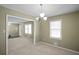 Open dining room with neutral walls, carpet, and a chandelier at 5620 Orly Ter, College Park, GA 30349