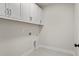 Laundry room with white cabinets and tile flooring at 495 Pearl St, Cumming, GA 30040