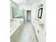 Bright bathroom featuring a soaking tub, glass-enclosed shower, and white vanity with double sinks and stylish fixtures at 4440 Sims Park Overlook, Suwanee, GA 30024