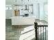 Bright kitchen with stainless steel appliances, large island, white cabinets, and light hardwood flooring at 4440 Sims Park Overlook, Suwanee, GA 30024