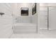 Modern bathroom featuring white tiled walls, tub and separate glass shower at 570 Silver Moon Dr, Loganville, GA 30052