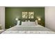 Inviting bedroom featuring a comfortable bed, green accent wall, complemented by stylish artwork and soft lighting at 570 Silver Moon Dr, Loganville, GA 30052