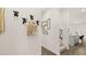 Hallway features decorative hooks, modern artwork, hard surface flooring, and view into the open concept living space at 570 Silver Moon Dr, Loganville, GA 30052