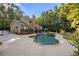 Expansive backyard featuring a sparkling pool with a stone surround, a deck, and lush landscaping for ultimate relaxation at 2010 Stonehedge Rd, Roswell, GA 30075