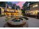 Backyard at dusk featuring a luxurious pool, hot tub, and multiple decks, beautifully illuminated for evening relaxation at 2010 Stonehedge Rd, Roswell, GA 30075